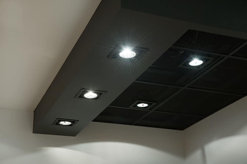 Close-up view of bright recessed downlight fixtures installed in a dark ceiling structure.