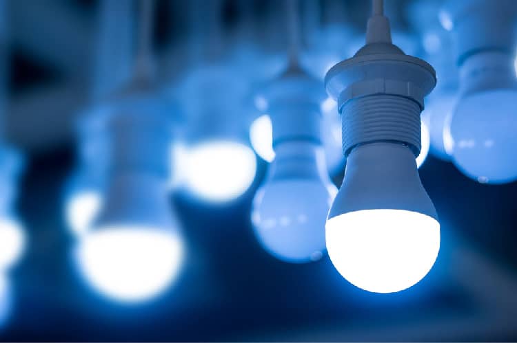 Glowing hanging LED bulbs with soft blue bokeh background