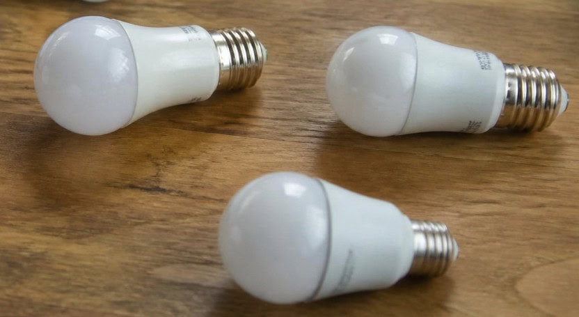 Three LED light bulbs laid on wood