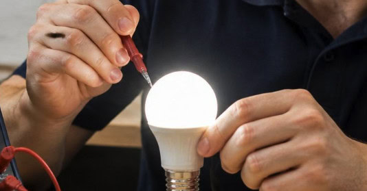 Technician testing LED light bulb to check flicker issue