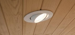 Adjustable tilt recessed ceiling light on wood planks